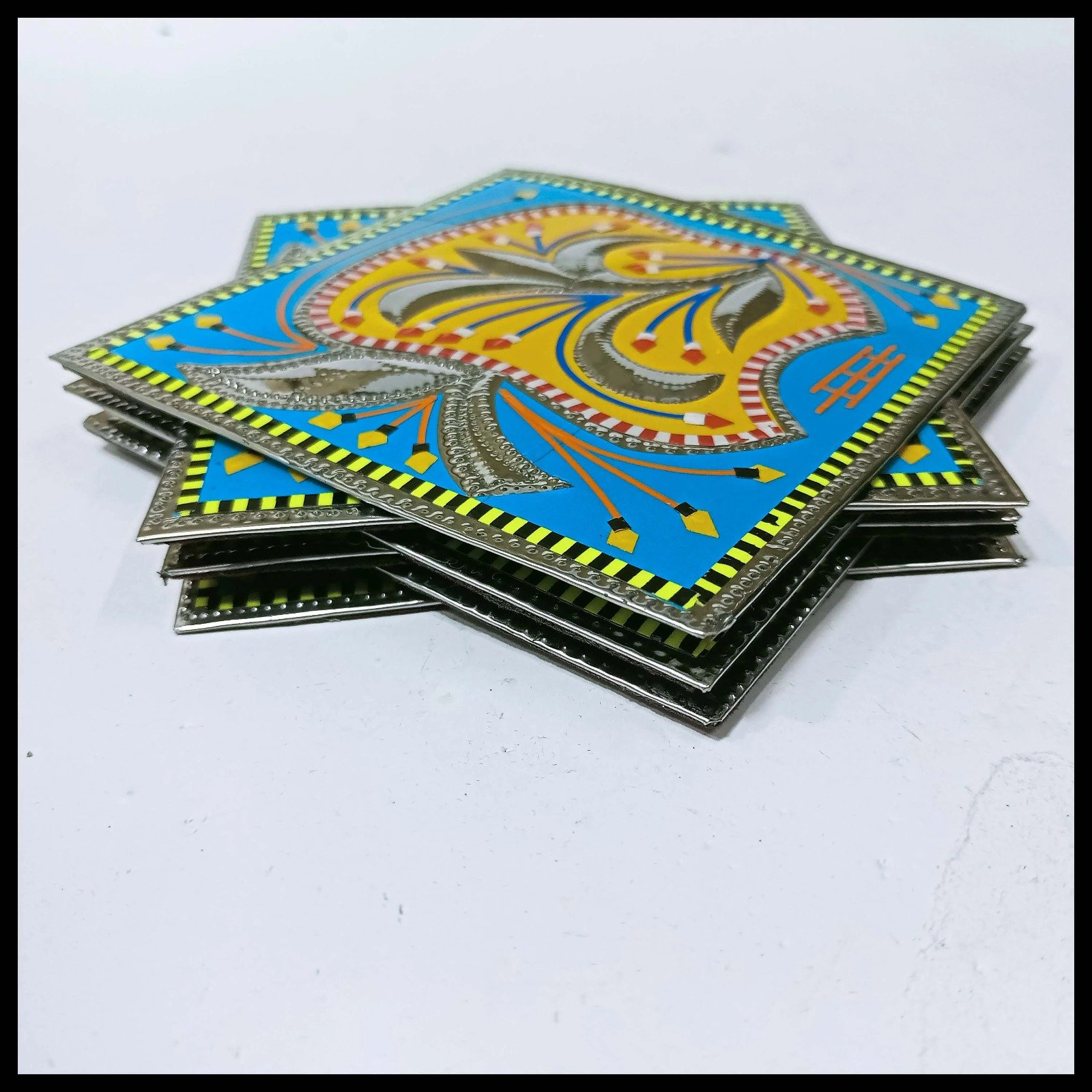 Close-up of single blue coaster with yellow floral truck art