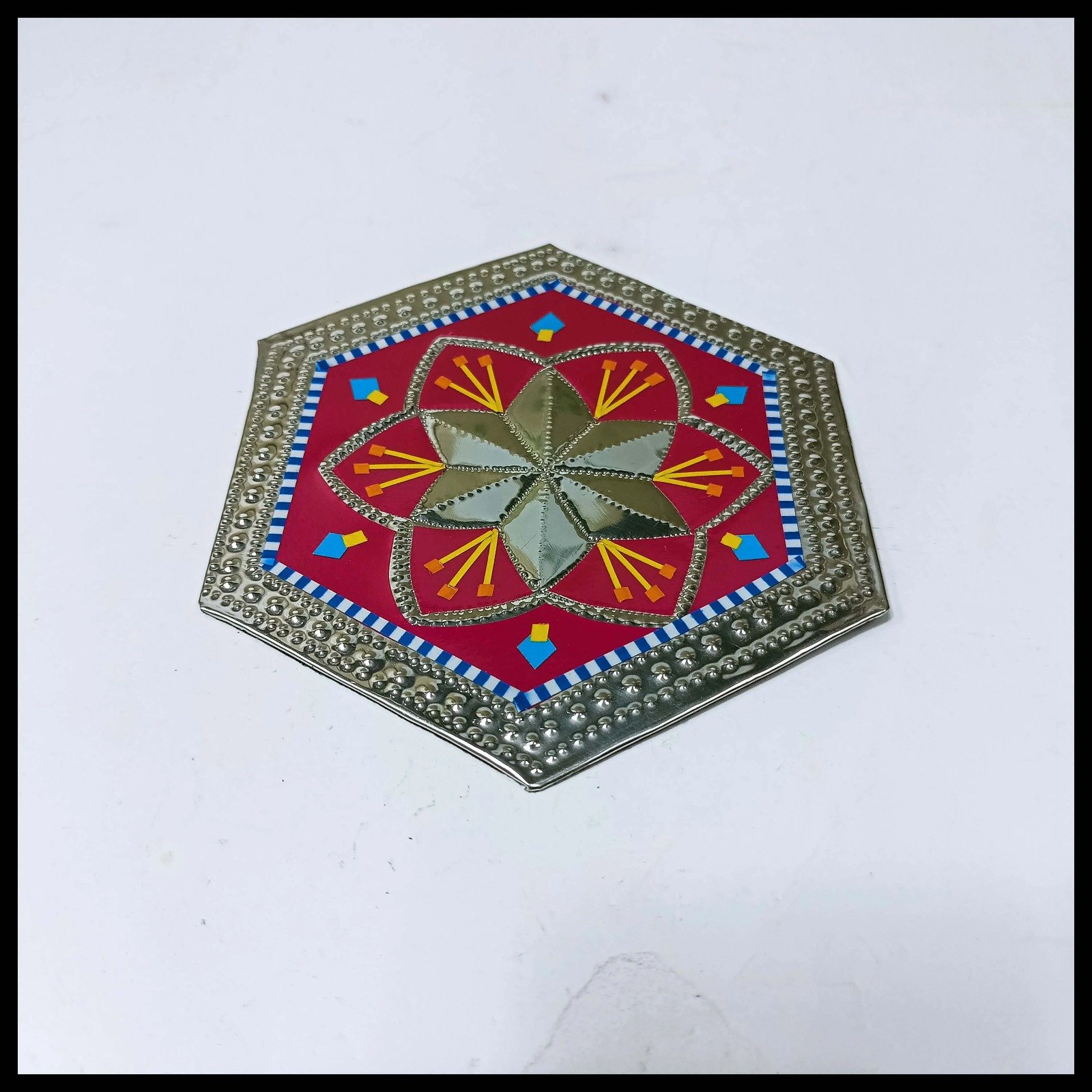 Vibrant hexagonal Chamakpatti tea coaster with red, gold, and blue details